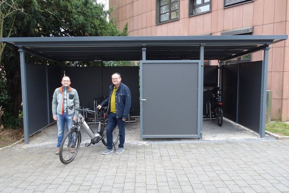 Nahmen gemeinsam die neue Fahrradabstellanlage im Außenbereich des Losheimer Rathauses in Augenschein: Bürgermeister Helmut Harth (rechts im Bild) und Werner Ludwig, Fachbereichsleiter „Umwelt und Gemeindeentwicklung“. Foto: J. Drehmann.